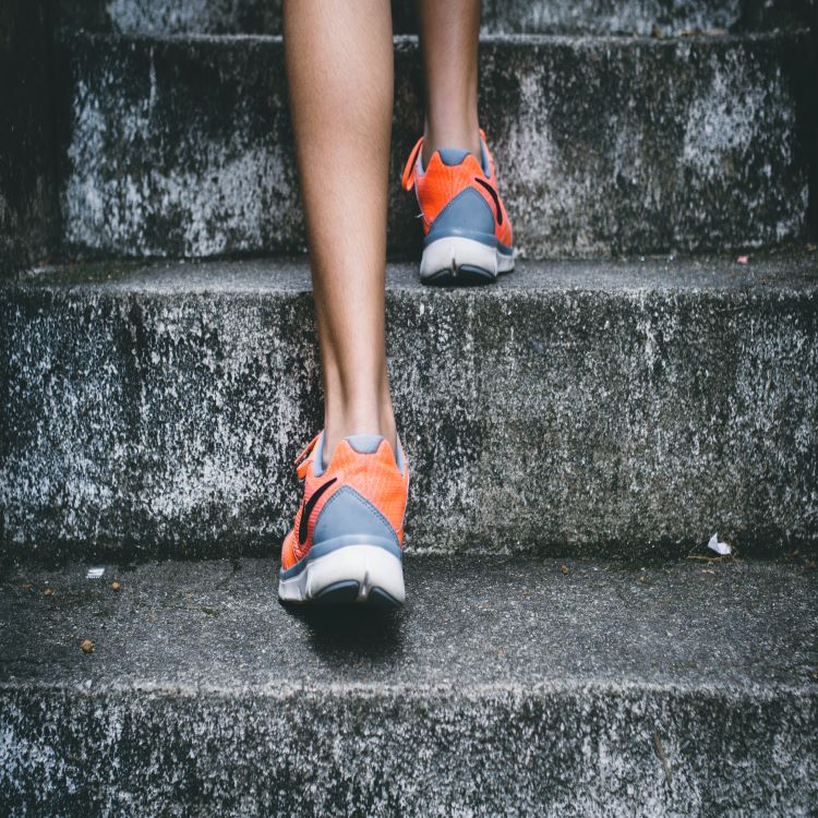 Picture of women's legs in running shoes walking up a staircase